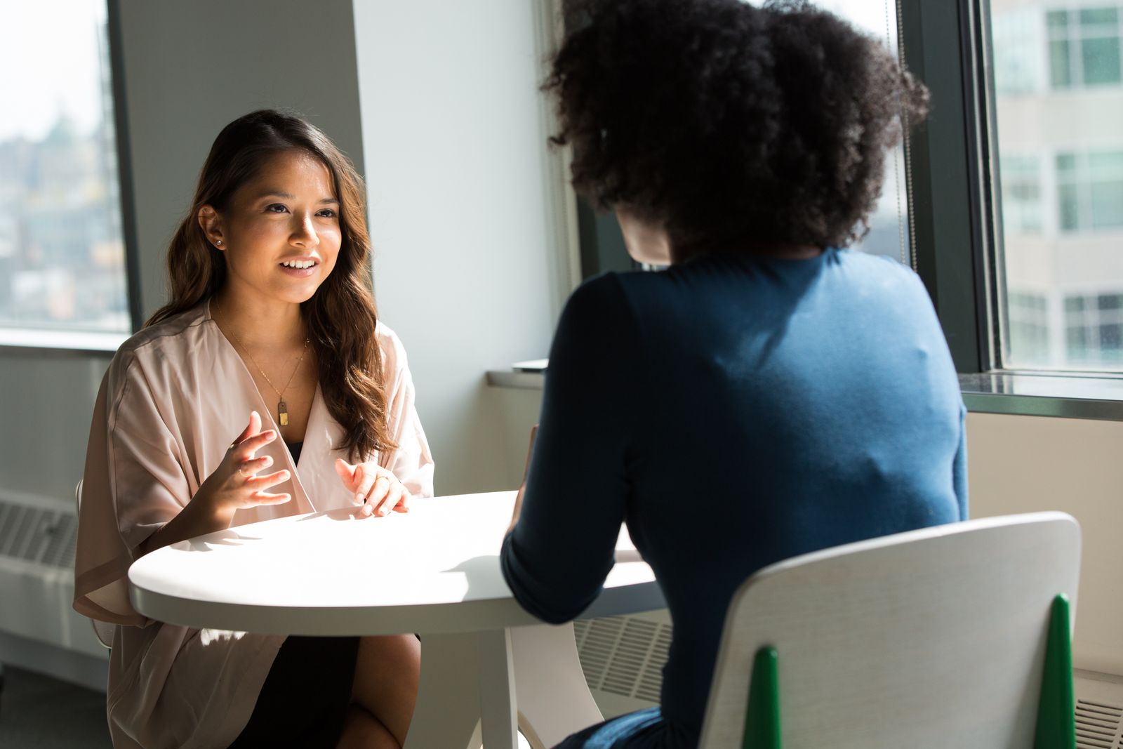 Two people talking across a small table