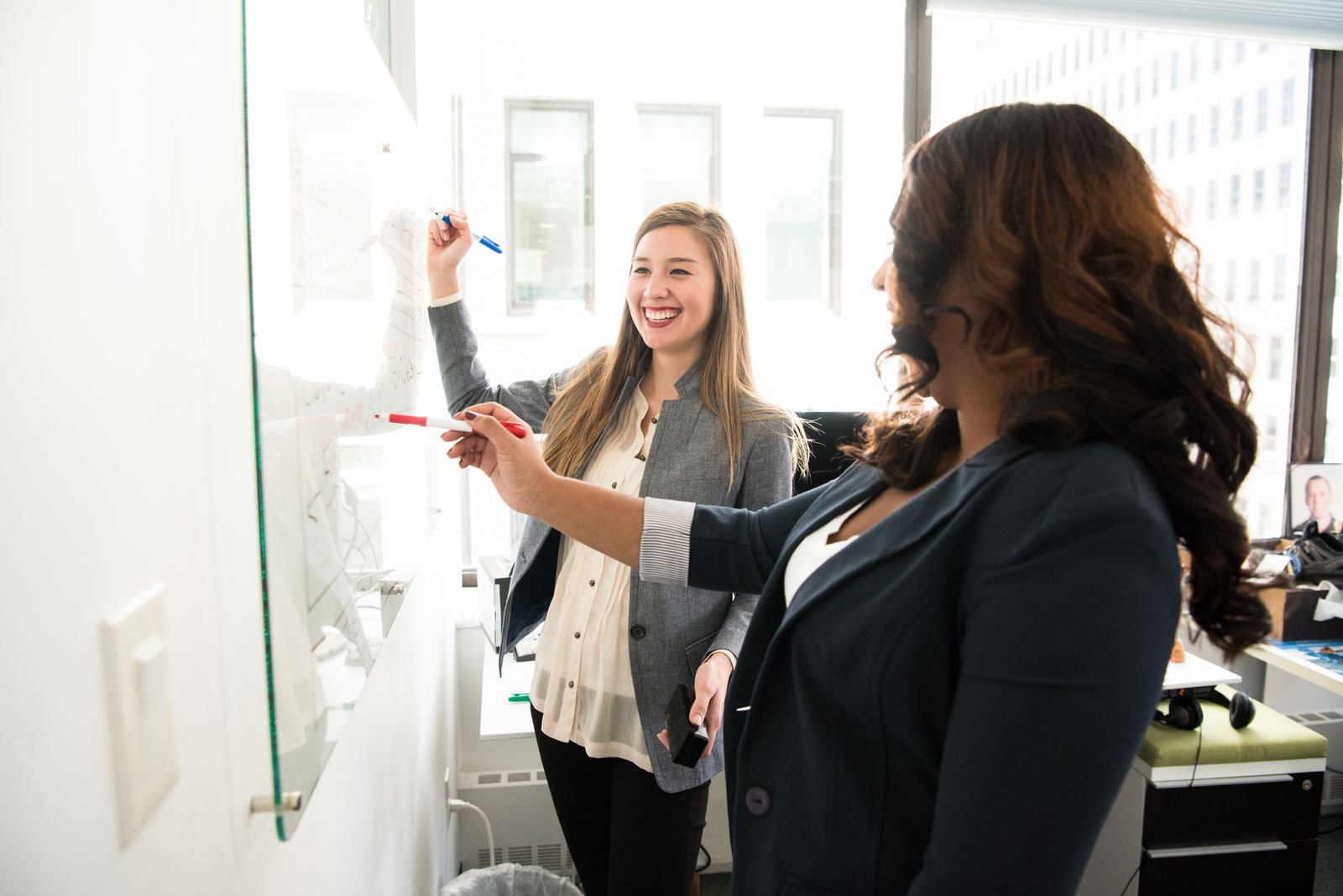 Two colleagues planning on a whiteboard