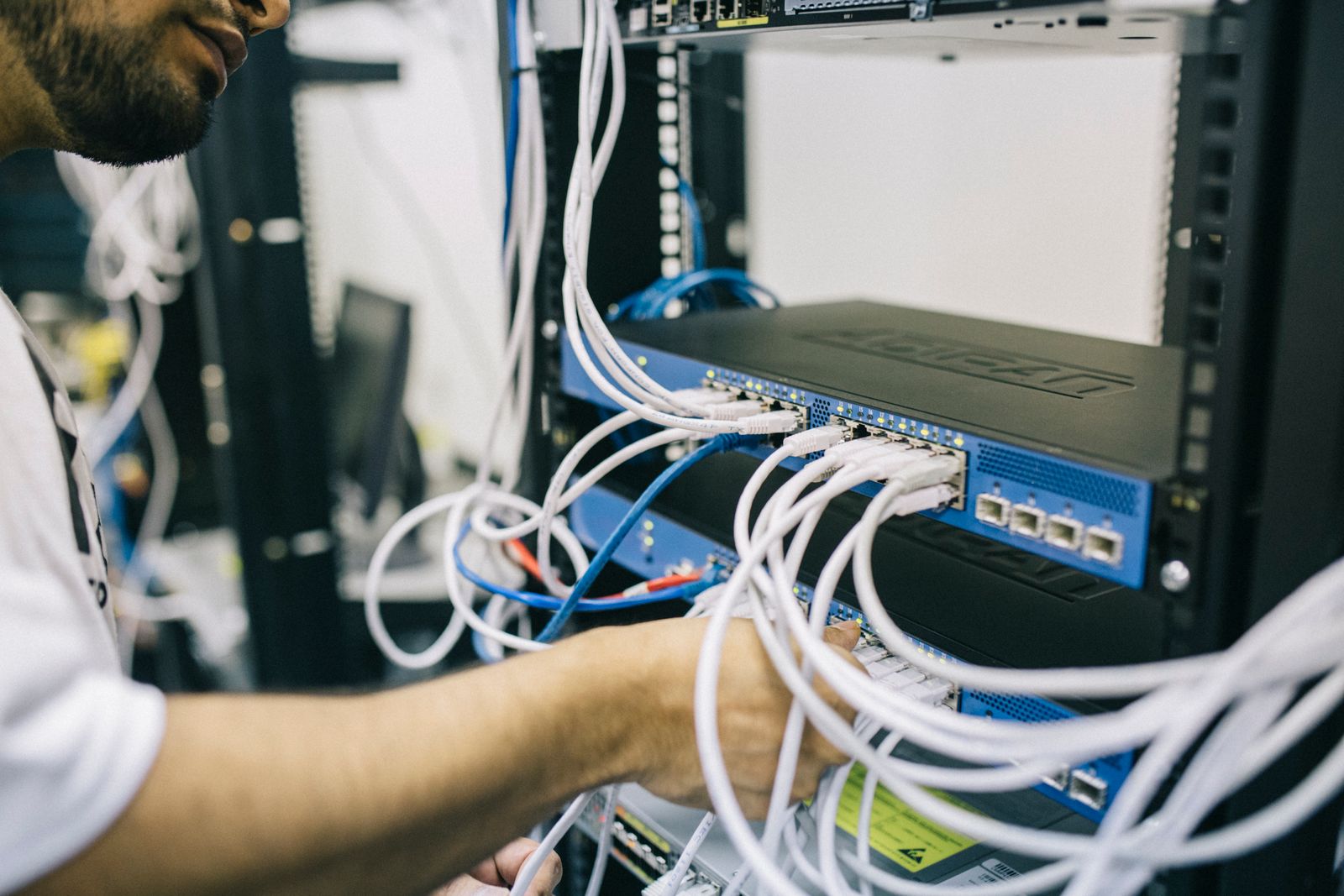Technician connecting cables in a server rack