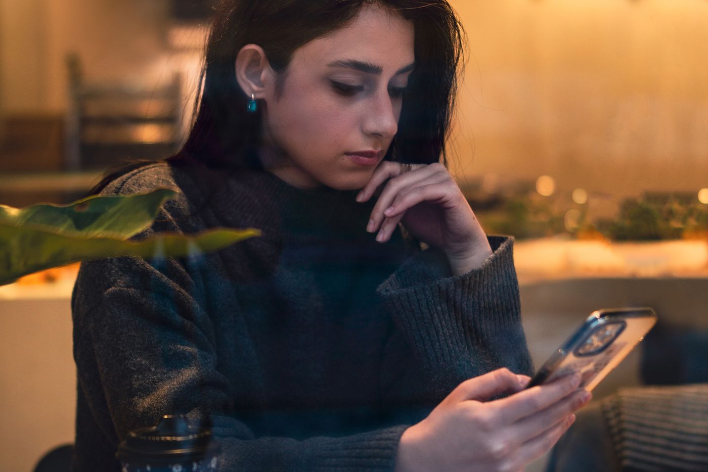 Woman reading email on her phone in a cafe