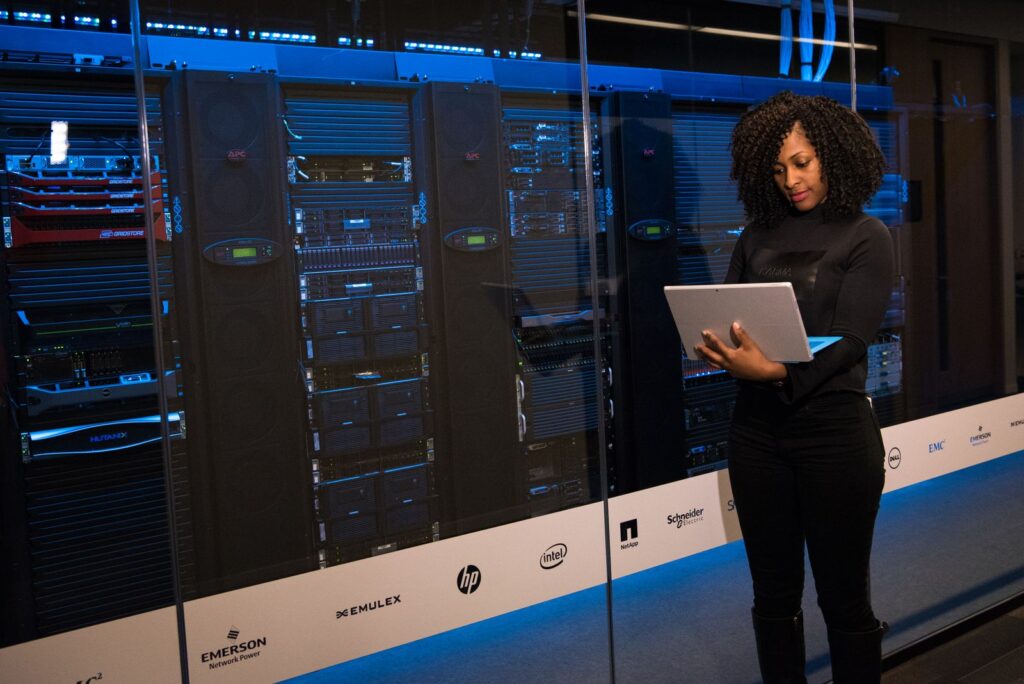 Administrator with a tablet standing beside server racks