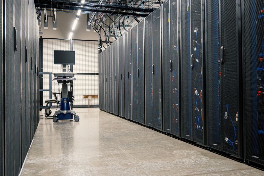 Rows of server racks in a brightly lit data centre corridor